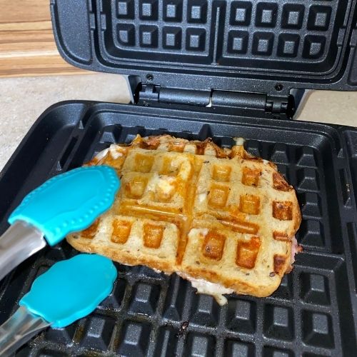 sandwich being taken out of waffle iron