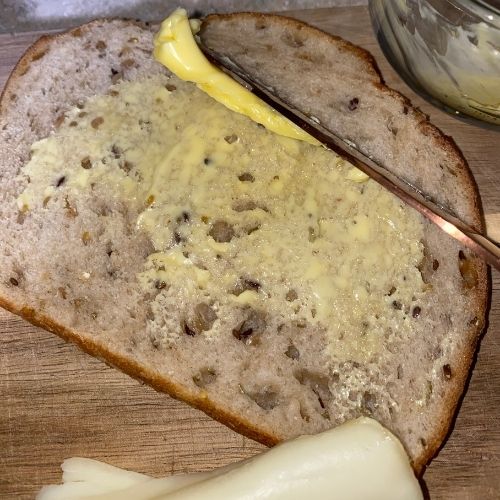 buttering a slice of bread with grass fed butter