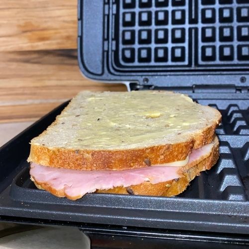buttered sandwich ready for waffle iron grilling