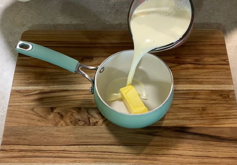 pouring milk into pan with butter to heat up