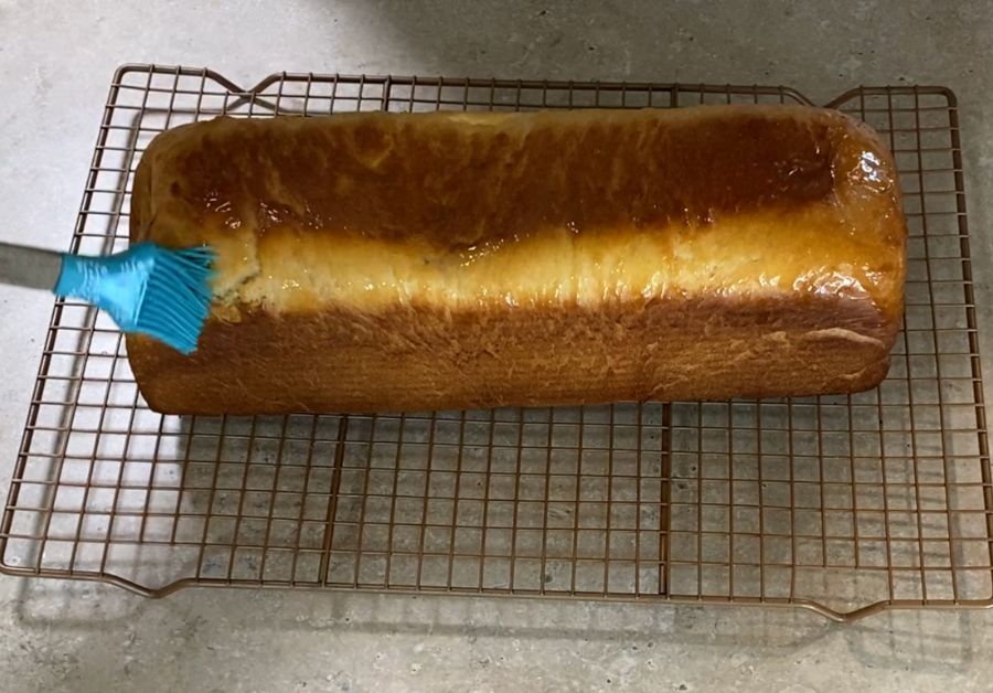 buttering a freshly baked homemade sandwich loaf