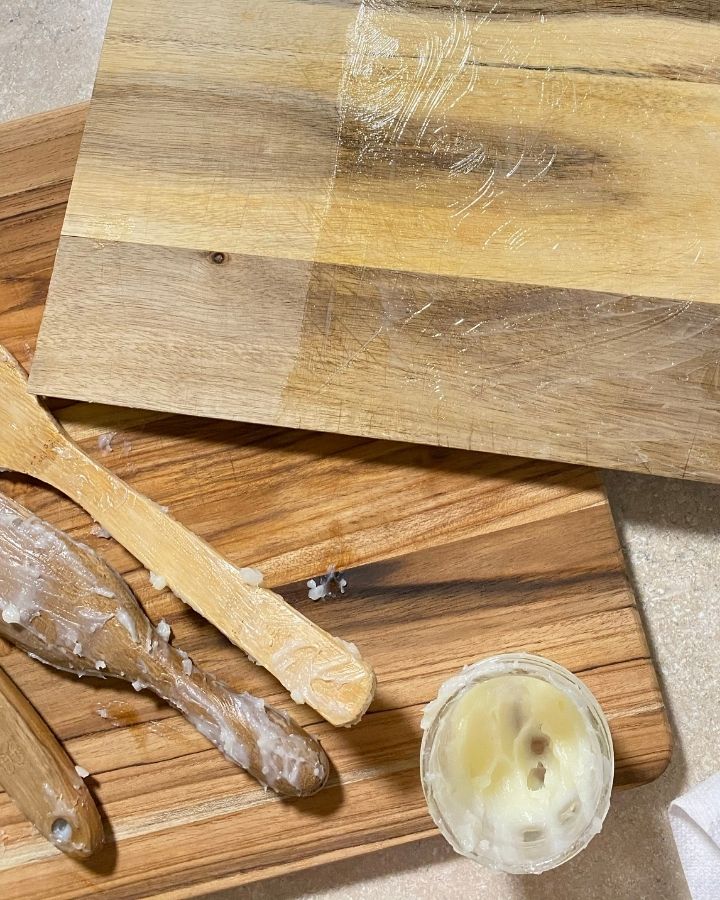 wooden spoons on a wooden cutting board covered in spoon butter