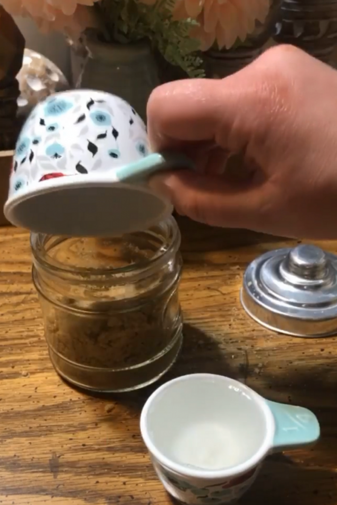 putting 1/2 cup of sugar into jar
