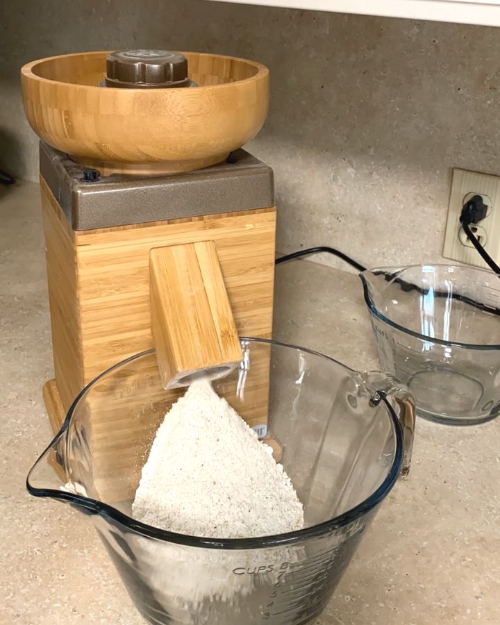 Grain mill grinding flour into a mixing bowl.