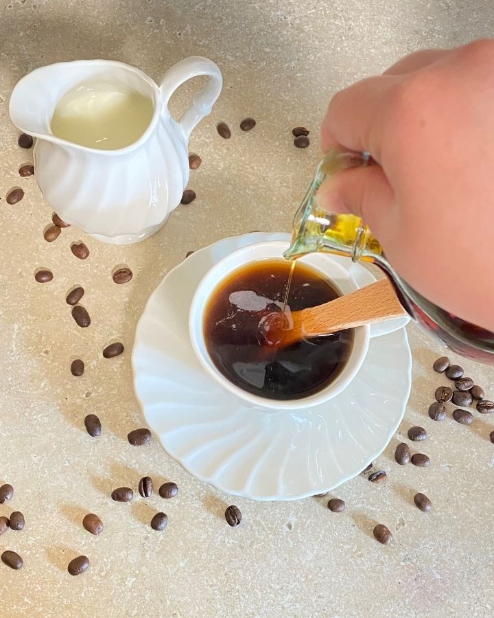 Pouring the maple syrup into hot coffee.